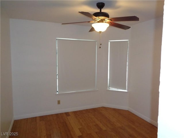 spare room featuring baseboards, a ceiling fan, and wood finished floors