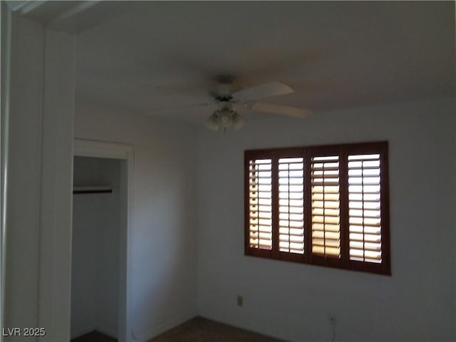 unfurnished bedroom with ceiling fan and a closet
