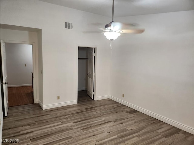 unfurnished bedroom with visible vents, baseboards, wood finished floors, and a closet