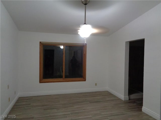 spare room featuring baseboards and light wood-type flooring
