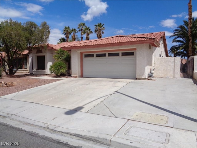 view of front of house featuring a garage, a tiled roof, driveway, and stucco siding