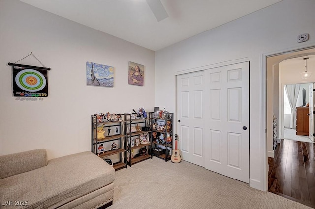 sitting room with a ceiling fan, arched walkways, and carpet