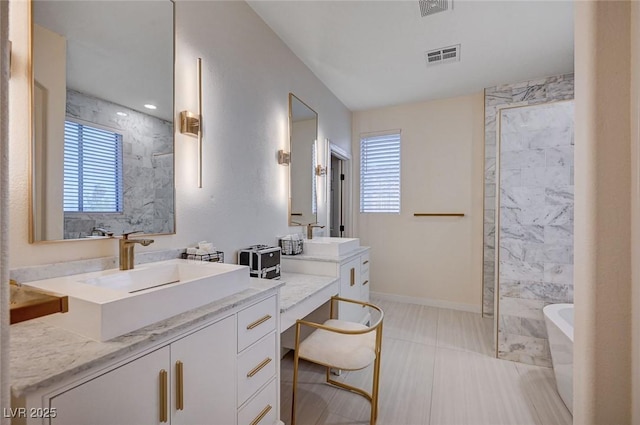 full bathroom with visible vents, a sink, and a freestanding tub