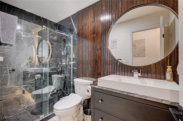 full bath with toilet, a marble finish shower, and vanity