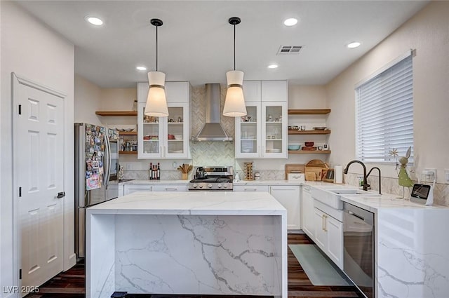 kitchen featuring wall chimney range hood, visible vents, open shelves, a sink, and stainless steel appliances