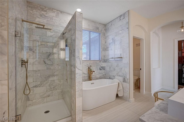 full bath featuring a freestanding bath, a stall shower, and toilet