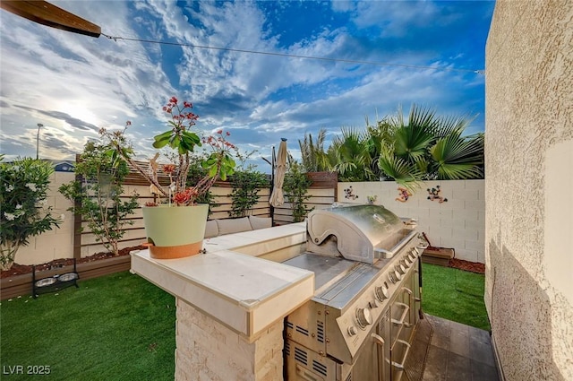 view of patio / terrace with grilling area, exterior kitchen, and a fenced backyard