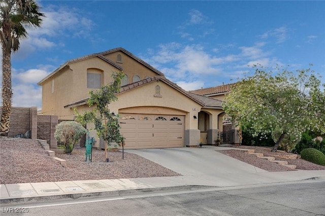 mediterranean / spanish home with a garage, stucco siding, driveway, and a tile roof