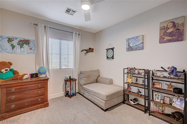 living area featuring ceiling fan, light colored carpet, and visible vents