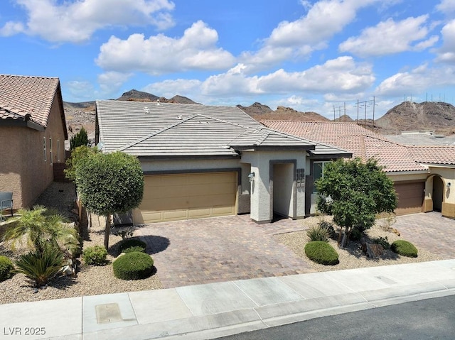 1063 Upper Springs St, Henderson, NV 89002 - view of front of house with a tile roof, a garage, decorative driveway, and stucco siding