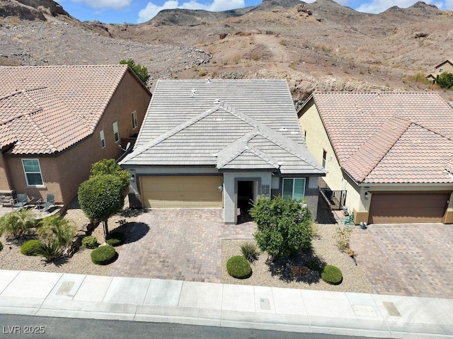 1063 Upper Springs St, Henderson, NV 89002 - view of front of home featuring a garage, stucco siding, driveway, and a tiled roof