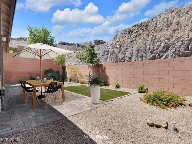 1063 Upper Springs St, Henderson, NV 89002 - fenced backyard featuring a mountain view, outdoor dining space, and a patio