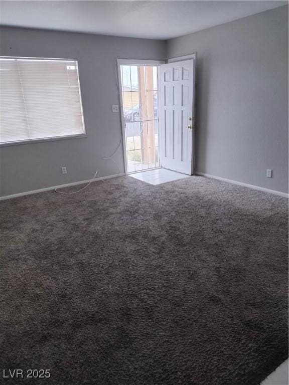 unfurnished room featuring carpet flooring and baseboards