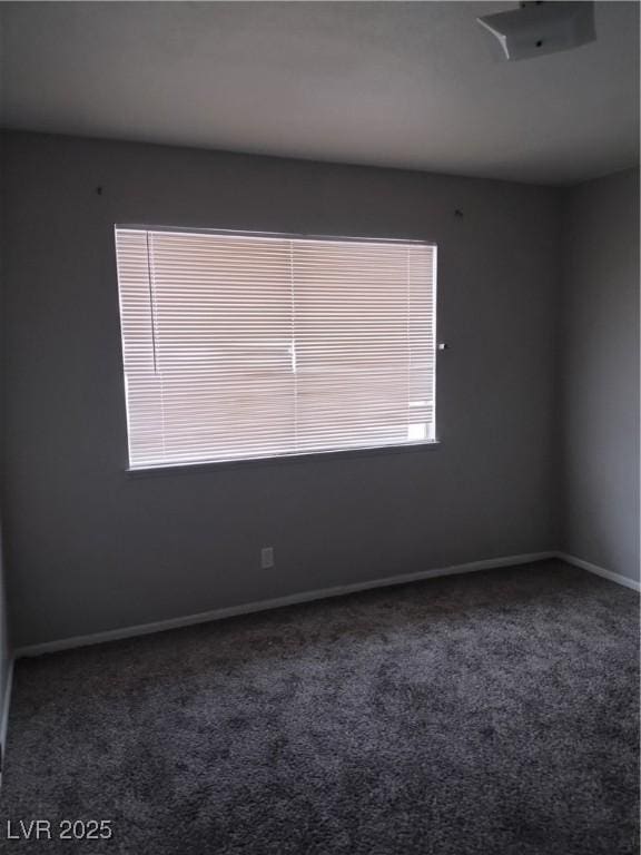 empty room featuring baseboards and carpet flooring