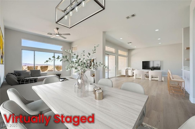 dining area featuring a ceiling fan, visible vents, plenty of natural light, and wood finished floors