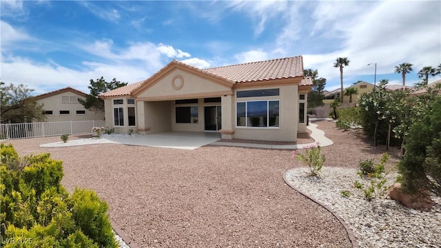 back of house featuring a patio, stucco siding, a tiled roof, and fence