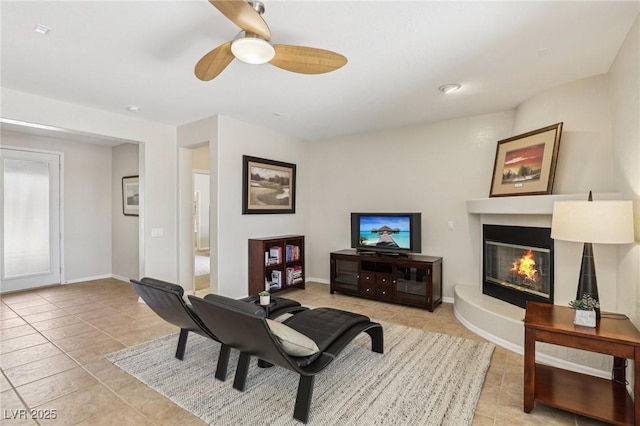 8316 Imperial Lakes St, Las Vegas, NV 89131 - living area featuring light tile patterned floors, ceiling fan, a glass covered fireplace, and baseboards