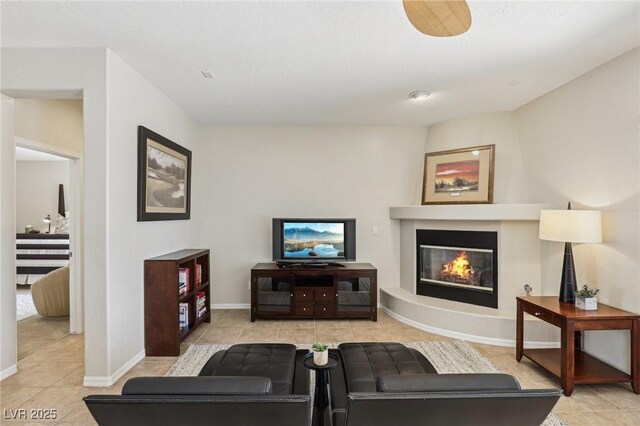 8316 Imperial Lakes St, Las Vegas, NV 89131 - living area with tile patterned floors, a glass covered fireplace, and baseboards