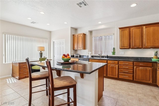 8316 Imperial Lakes St, Las Vegas, NV 89131 - kitchen with brown cabinets, a kitchen breakfast bar, light tile patterned flooring, recessed lighting, and a center island