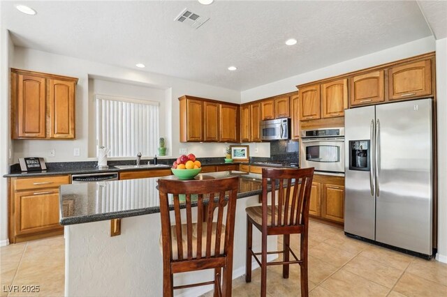 8316 Imperial Lakes St, Las Vegas, NV 89131 - kitchen with appliances with stainless steel finishes, a kitchen island, recessed lighting, a sink, and brown cabinetry