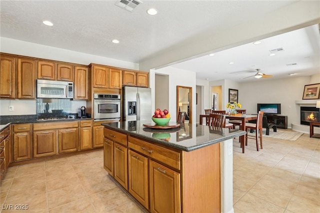 8316 Imperial Lakes St, Las Vegas, NV 89131 - kitchen featuring appliances with stainless steel finishes, brown cabinetry, a ceiling fan, a kitchen island, and recessed lighting