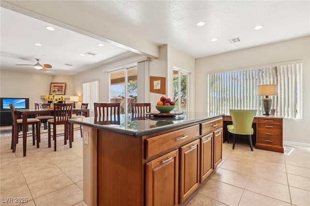 8316 Imperial Lakes St, Las Vegas, NV 89131 - kitchen featuring light tile patterned flooring, recessed lighting, brown cabinetry, a ceiling fan, and a center island
