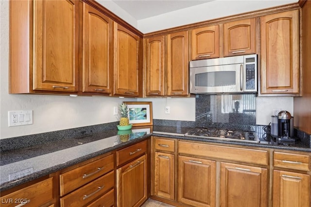 8316 Imperial Lakes St, Las Vegas, NV 89131 - kitchen featuring stainless steel appliances, dark stone counters, and brown cabinets