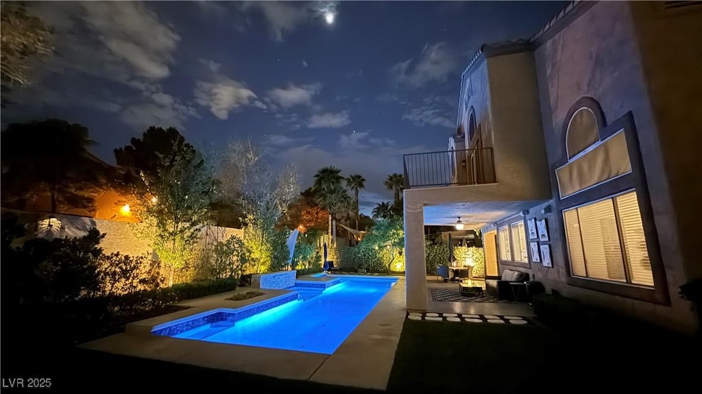 pool at night with a fenced in pool, a patio, a jacuzzi, and a fenced backyard