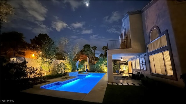 pool at night with a fenced in pool, a patio, a jacuzzi, and a fenced backyard