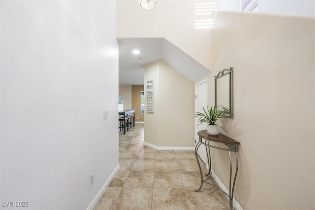 hall with baseboards and light tile patterned floors