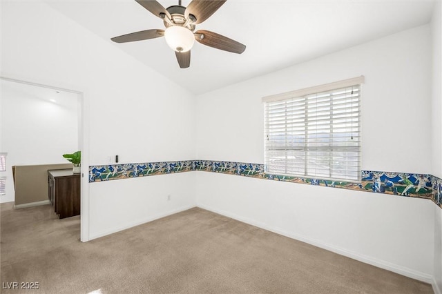 carpeted spare room with baseboards and a ceiling fan
