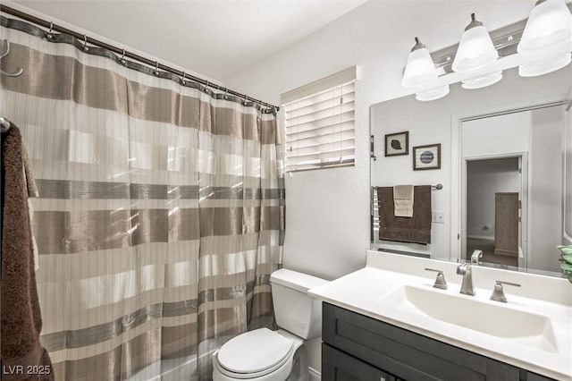bathroom with vanity, a textured wall, toilet, and a shower with shower curtain