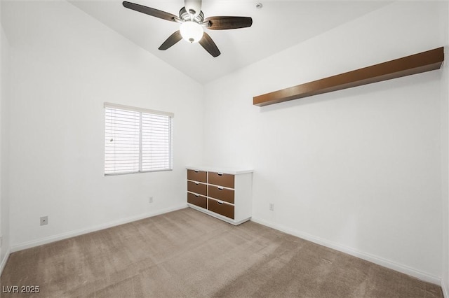 spare room featuring baseboards, ceiling fan, light carpet, and lofted ceiling