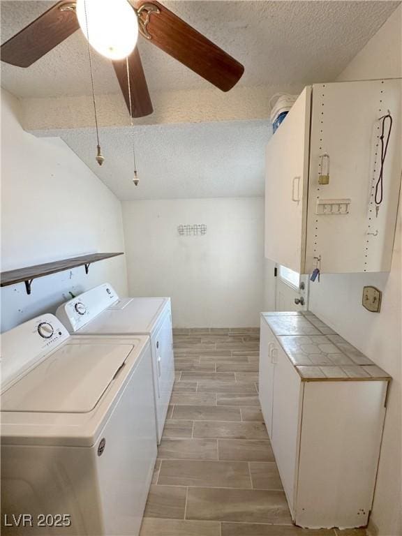 clothes washing area featuring washing machine and clothes dryer, a textured ceiling, and laundry area