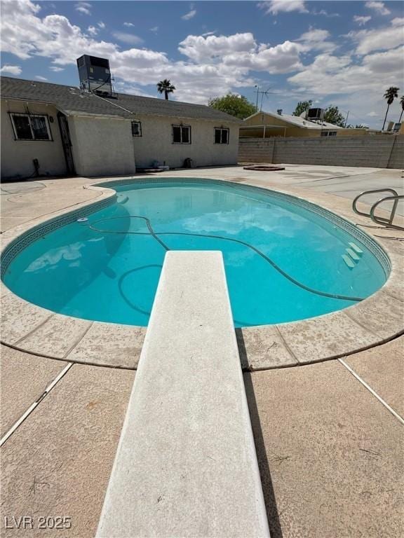 view of pool with a patio, central AC, a fenced in pool, and fence