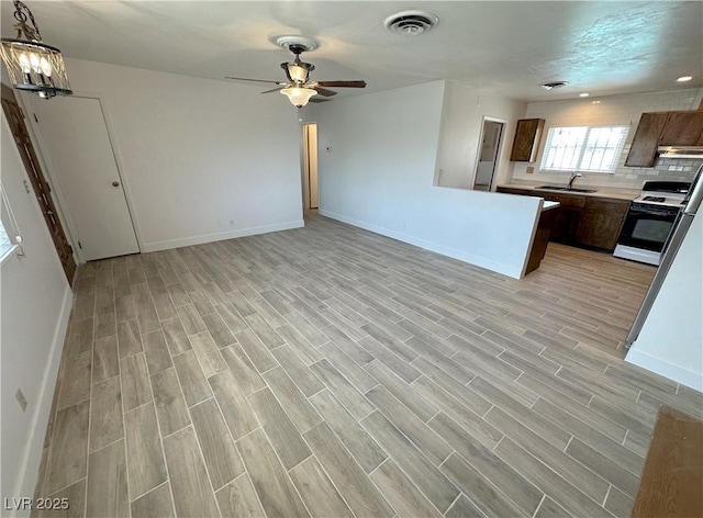 kitchen with visible vents, range with gas stovetop, baseboards, light wood-type flooring, and a sink