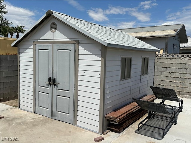 view of shed featuring fence