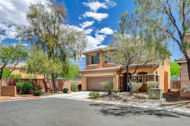 mediterranean / spanish-style home featuring a tiled roof, fence, concrete driveway, an attached garage, and stucco siding