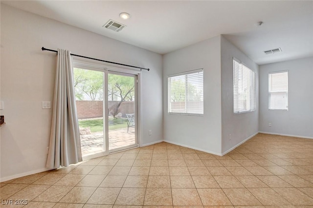 spare room with visible vents, baseboards, and light tile patterned flooring