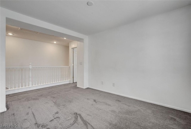 carpeted empty room featuring baseboards