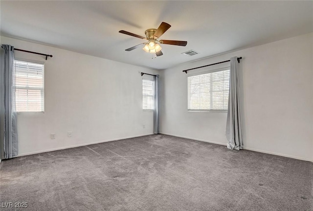 unfurnished room with visible vents, carpet, ceiling fan, and baseboards