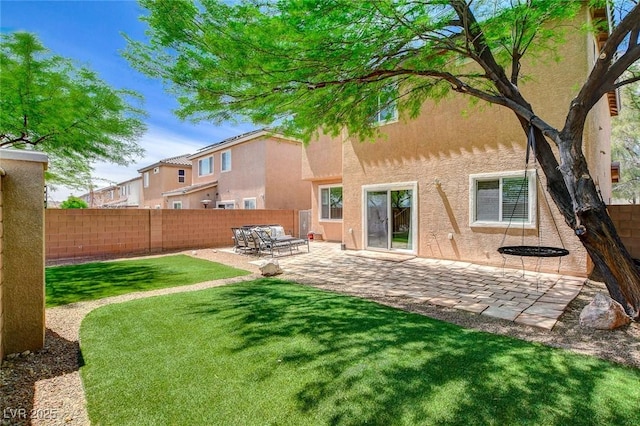back of property with a patio, a fenced backyard, a lawn, and stucco siding