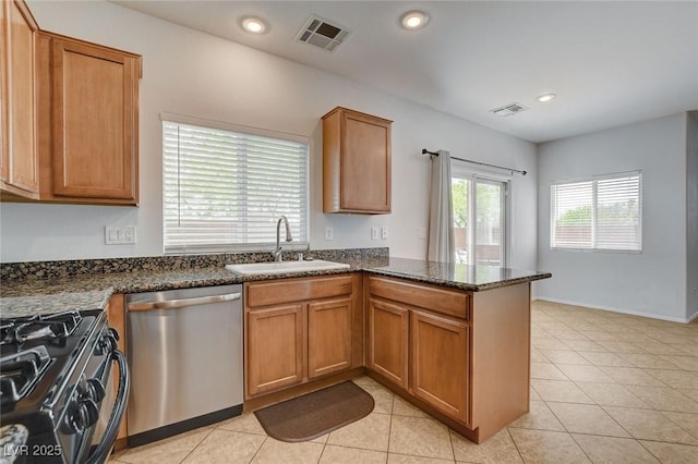 kitchen with brown cabinets, a sink, a peninsula, stainless steel dishwasher, and visible vents