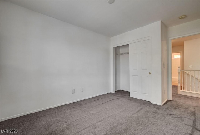 unfurnished bedroom featuring carpet floors, baseboards, and a closet