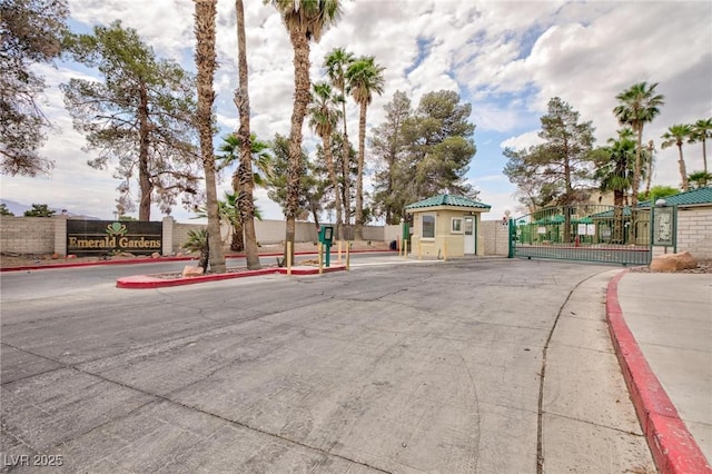 view of street with a gate, curbs, a gated entry, and sidewalks