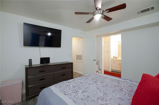 bedroom featuring connected bathroom, visible vents, wood finished floors, and a ceiling fan