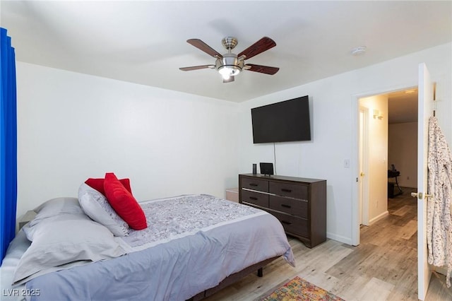 bedroom with baseboards, light wood finished floors, and ceiling fan