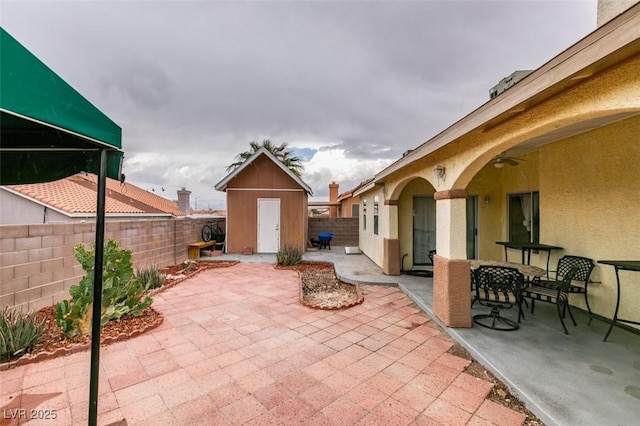 2595 Fort Lauderdale Dr, Las Vegas, NV 89156 - view of patio with a storage unit, an outdoor structure, a fenced backyard, and outdoor dining space