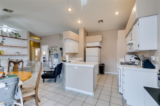 2595 Fort Lauderdale Dr, Las Vegas, NV 89156 - kitchen with white appliances, a peninsula, a ceiling fan, white cabinets, and lofted ceiling