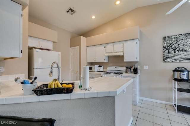 2595 Fort Lauderdale Dr, Las Vegas, NV 89156 - kitchen with white appliances, lofted ceiling, a peninsula, under cabinet range hood, and tile countertops